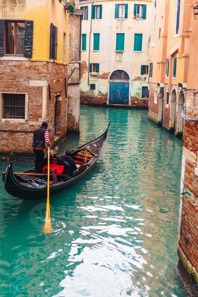 canal veneziano com casas antigas e barcos foto