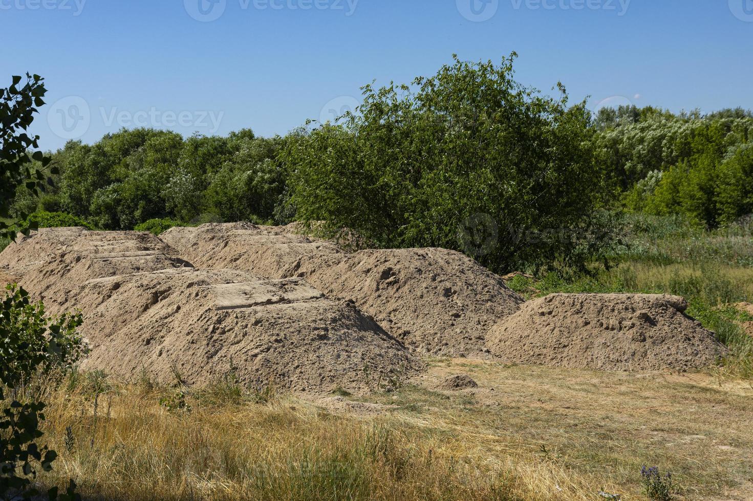 areia de construção. montanha de areia no canteiro de obras. terra escavada. foto