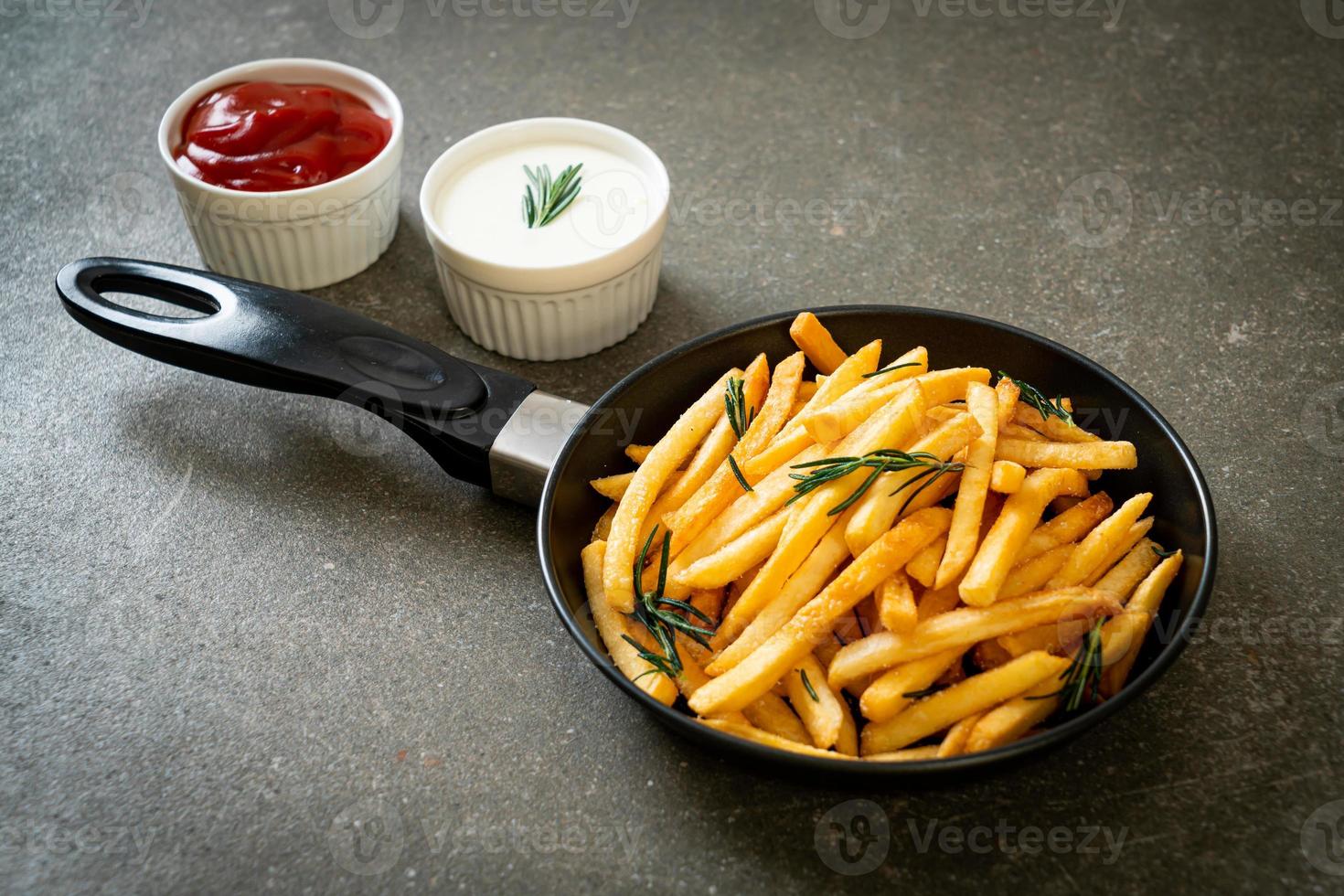 batatas fritas com creme de leite e ketchup foto