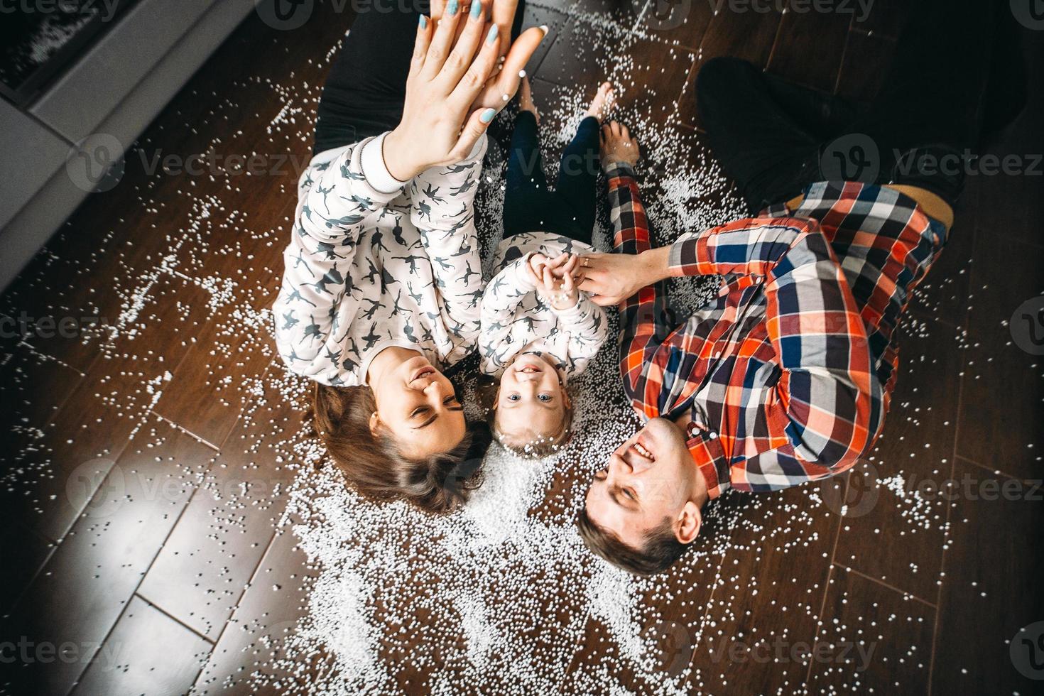 família feliz jogando juntos no chão foto