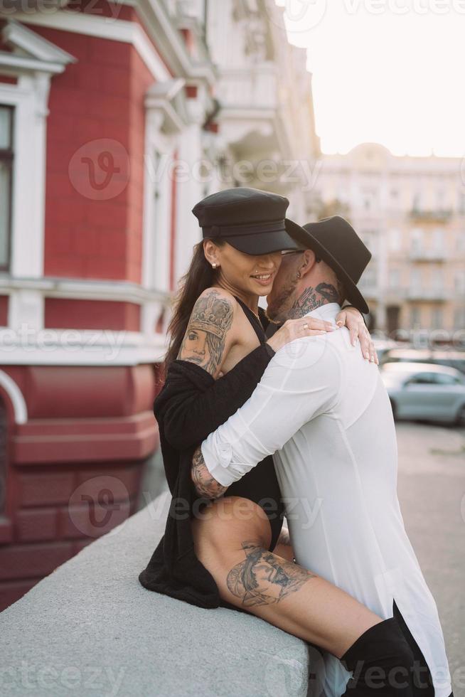 um jovem e sexy casal de amantes posam para uma câmera nas ruas foto