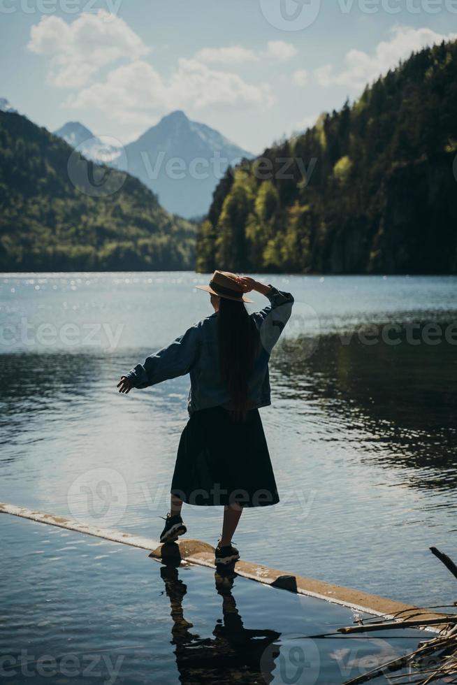 a garota de vestido e chapéu do lago nas montanhas foto