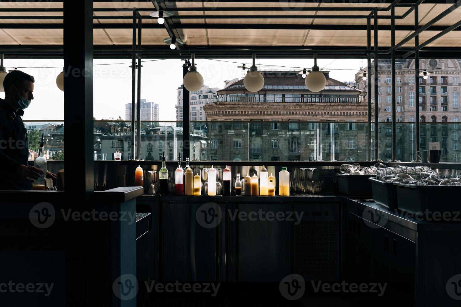 garçom em uma máscara de proteção médica no restaurante foto