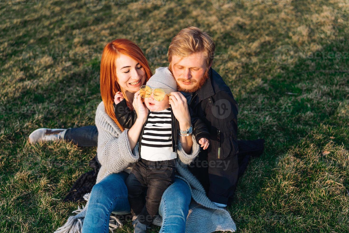 mãe feliz pai e filho abraçando no parque foto