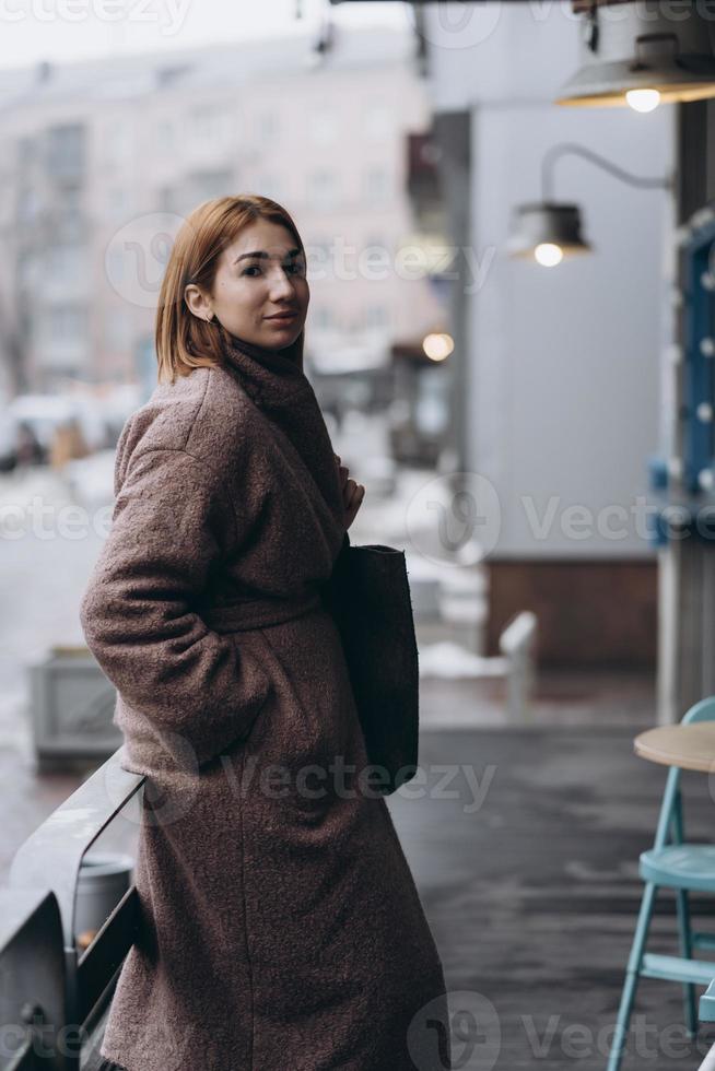 mulher atraente em trench coat na rua da cidade foto