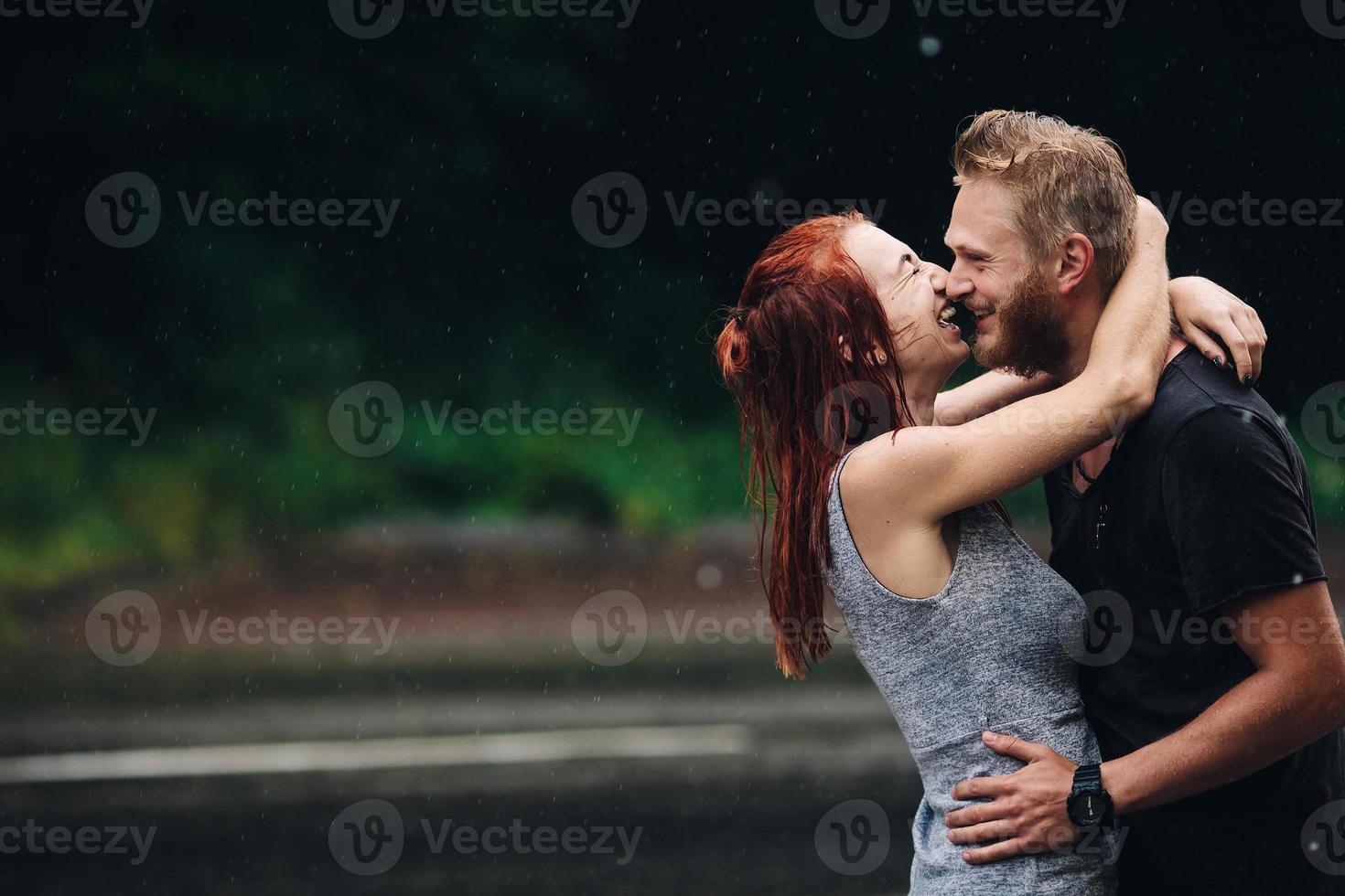 lindo casal abraçando na chuva foto