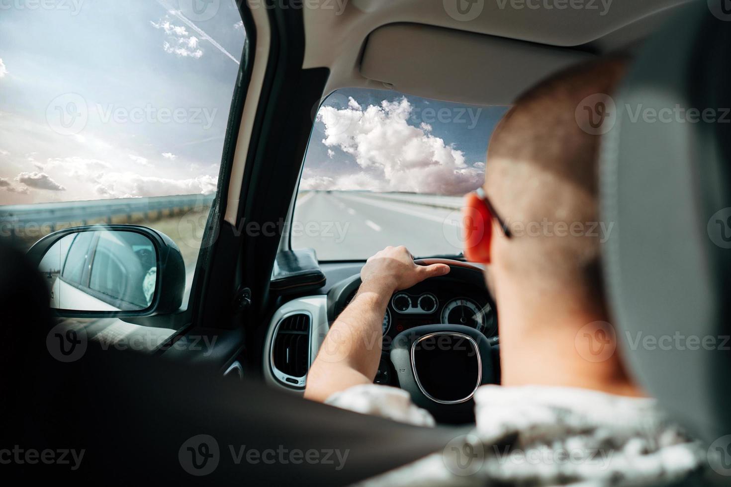o homem no carro viajando na estrada foto