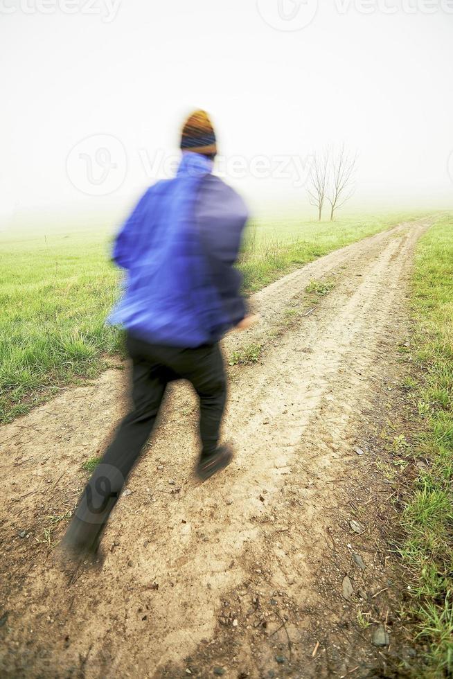 homem correndo em uma estrada de terra foto