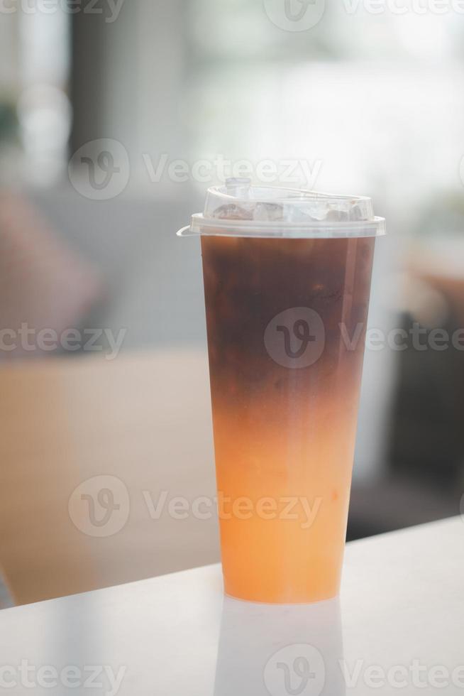 café preto gelado gelado misturado suco de laranja em um copo. foto