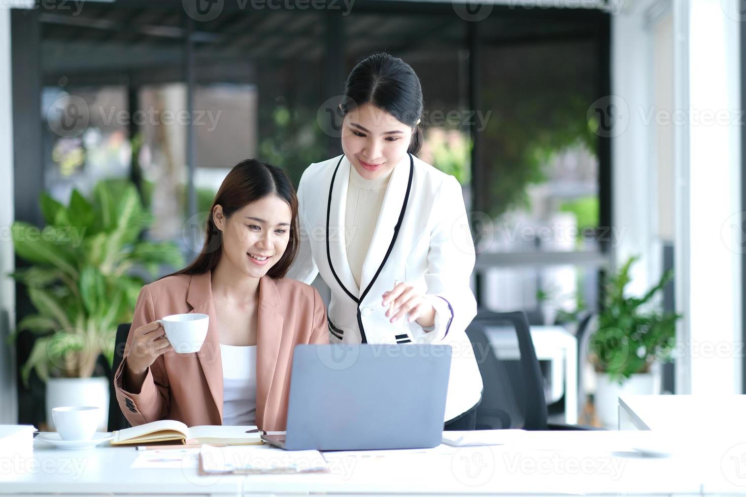 duas jovem empresária asiática discutem com a nova apresentação da ideia do projeto de inicialização, analisam o planejamento e as estatísticas financeiras e o mercado de investimentos no escritório. foto