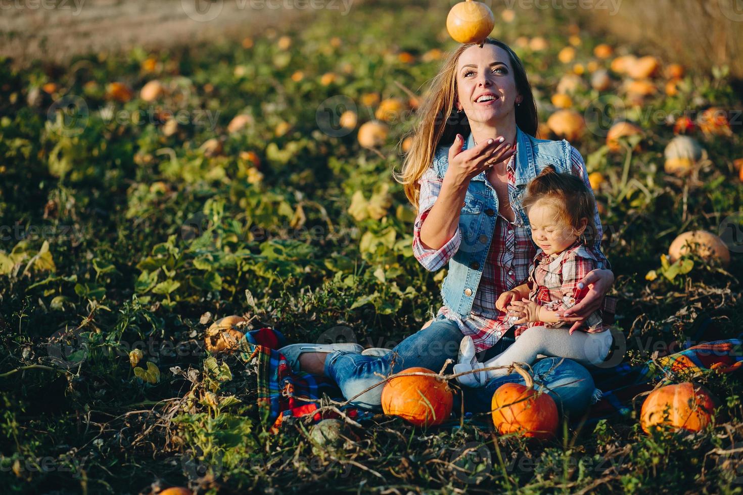 mãe e filha em um campo com abóboras foto