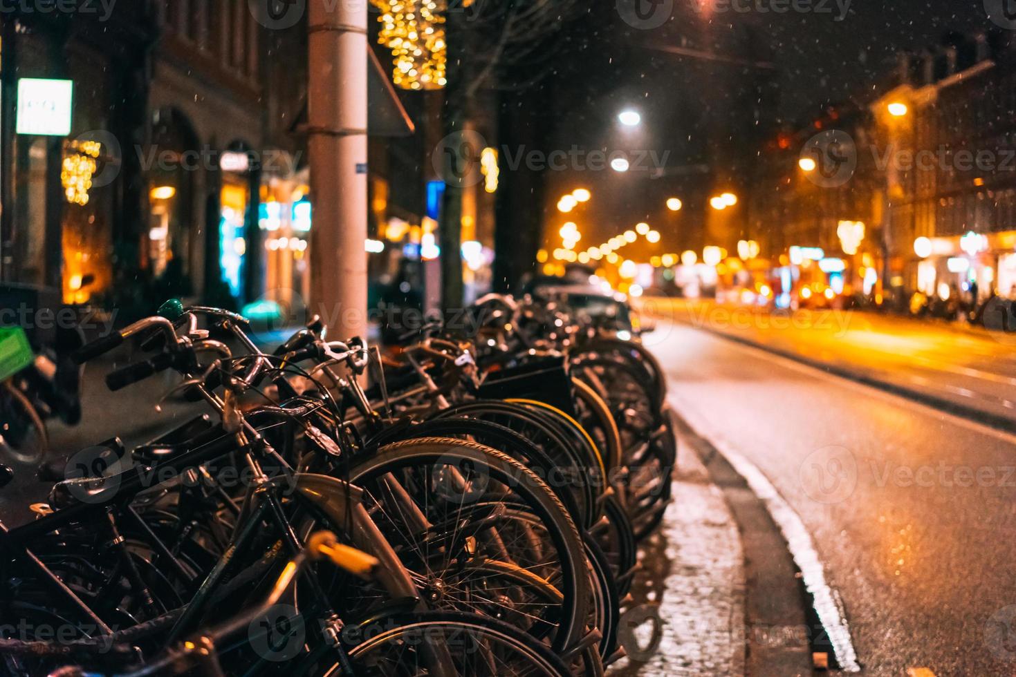 bicicletas estacionadas ao longo da estrada, noite foto