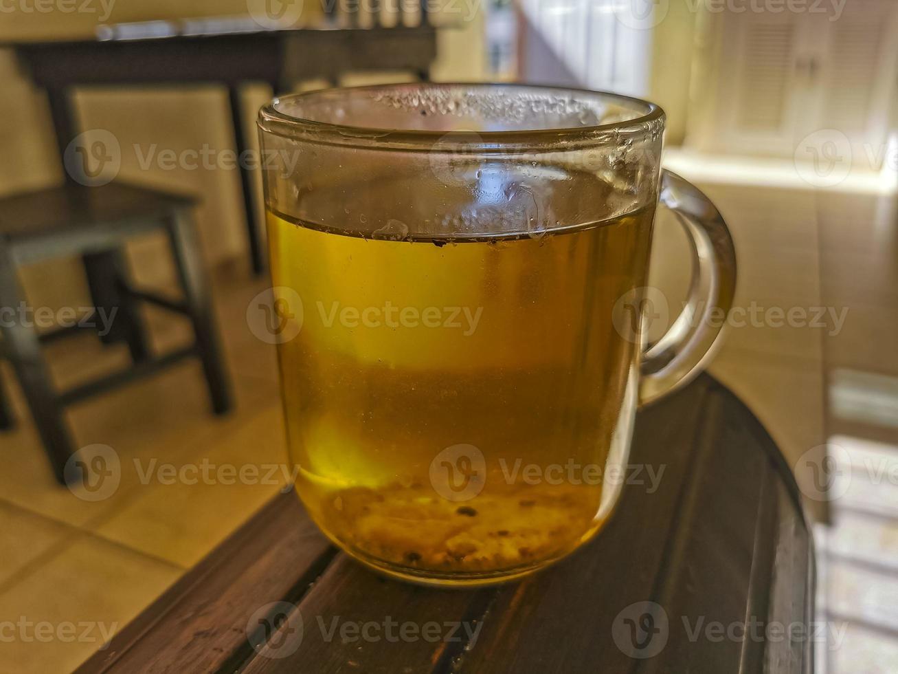 pote de vidro ou xícara com chá de gengibre quente. foto