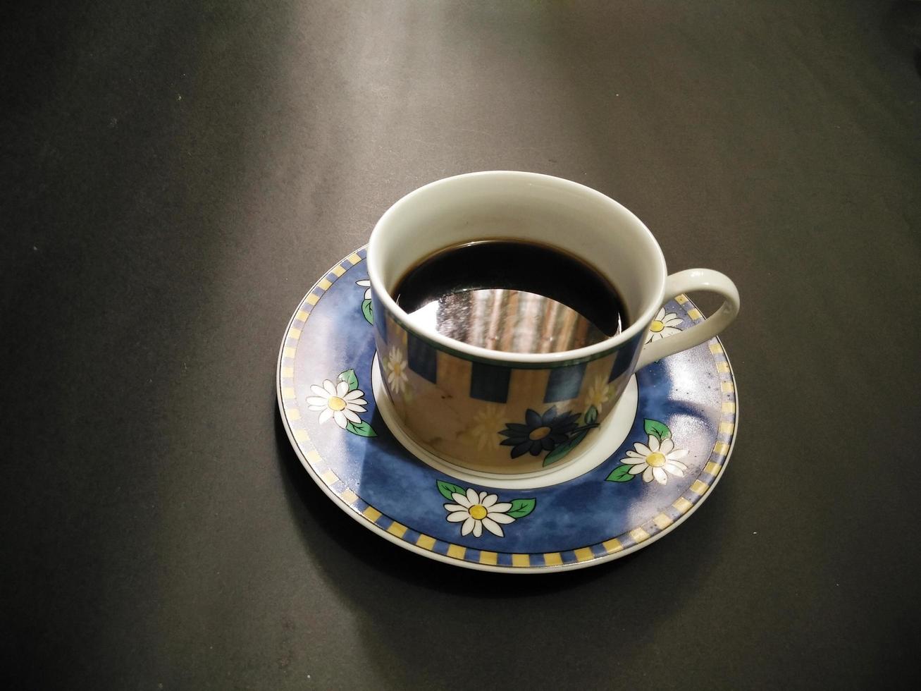 padrão floral de xícara de café em fundo preto foto