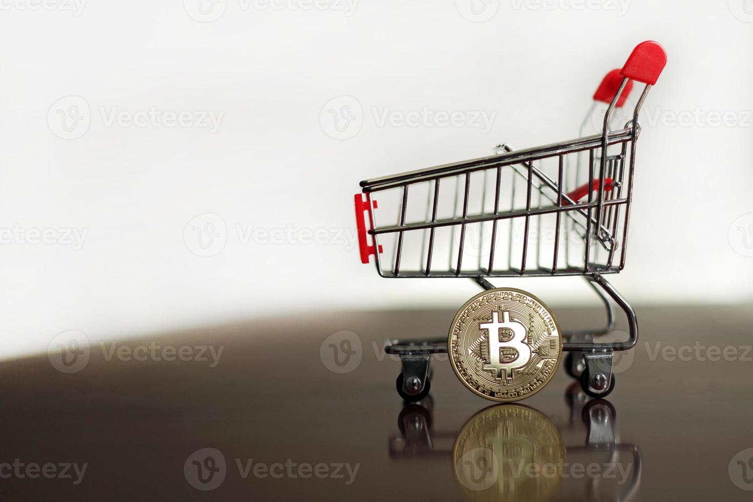 bitcoin brilhante e um carrinho de compras foto