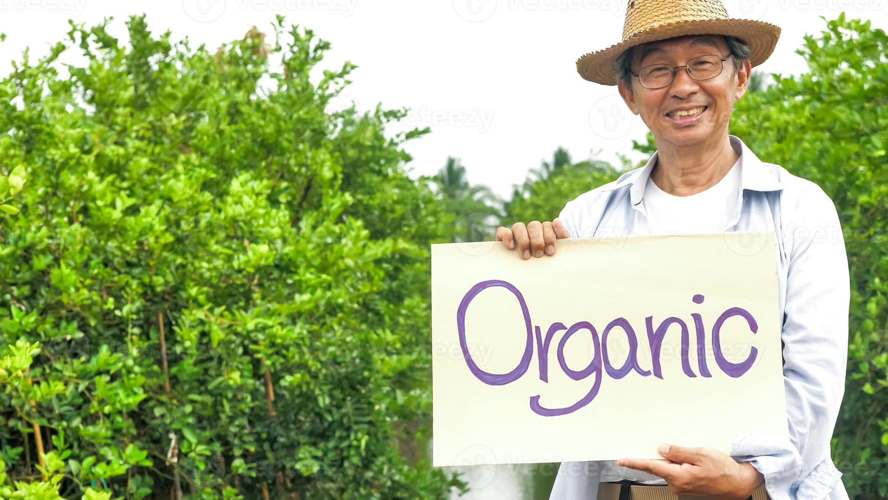 agricultor feliz sorrindo e de pé na fazenda orgânica. foto