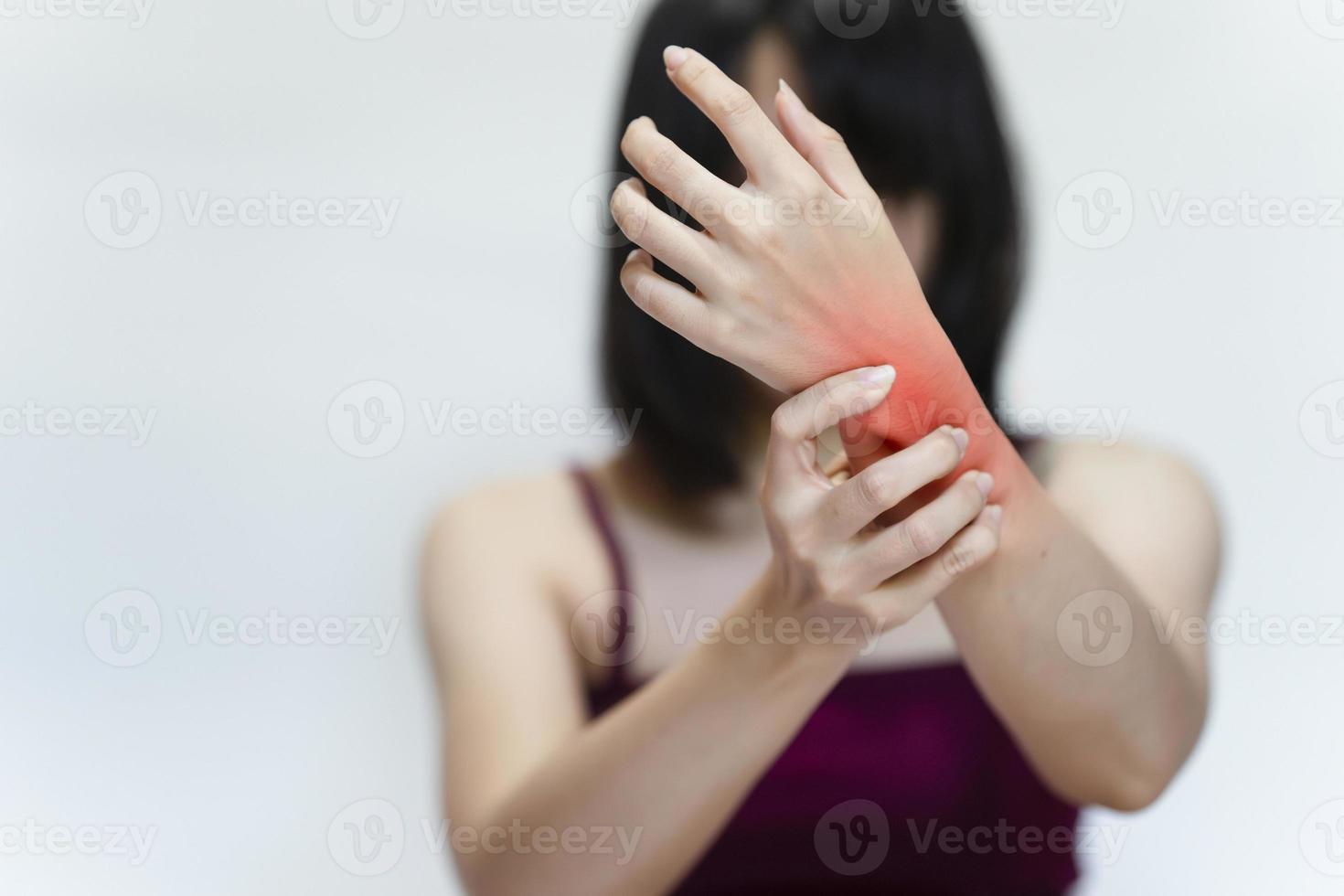 mulher com lesão no pulso em fundo cinza. foto