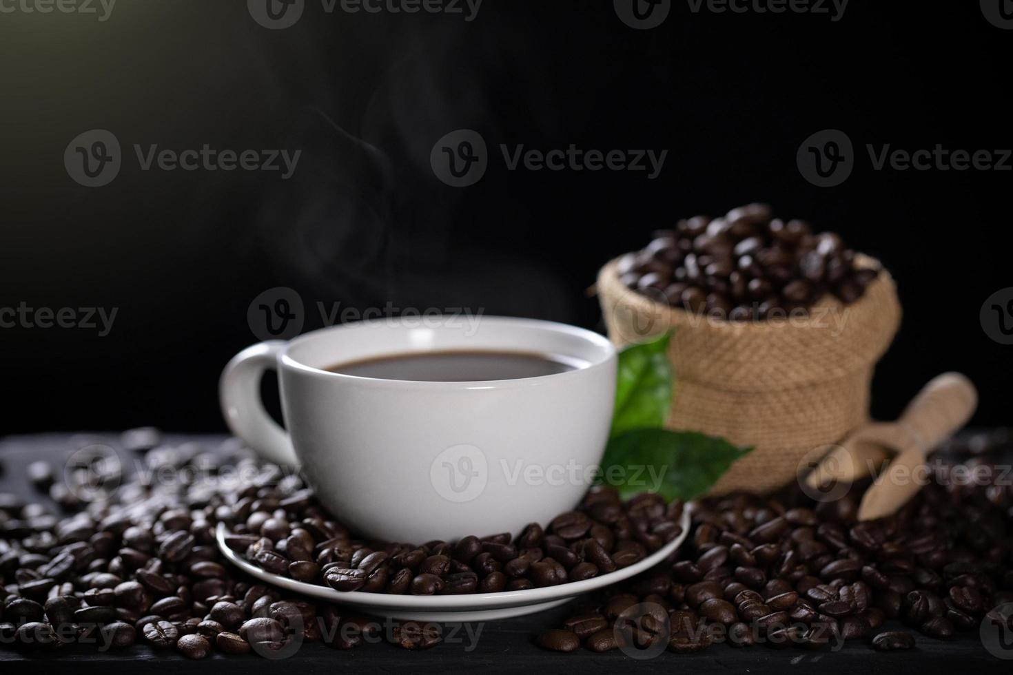 xícara de café quente com grãos de café na mesa de madeira foto