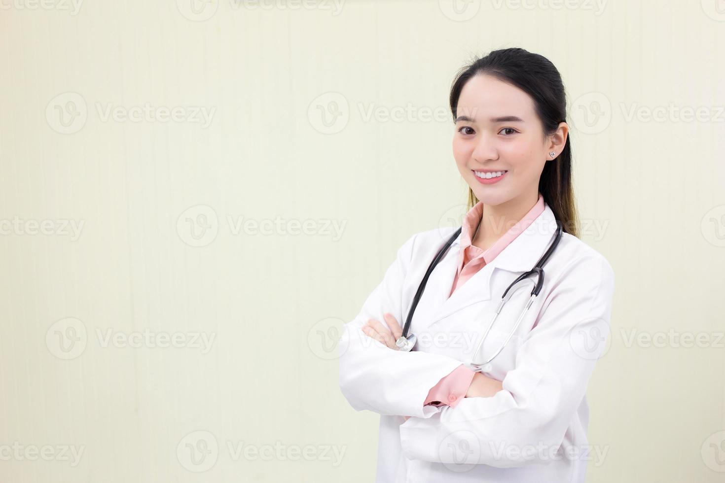 médica asiática fica e cruza os braços no escritório no hospital. foto