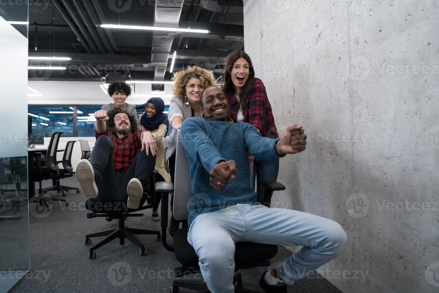 equipe de negócios multiétnica competindo em cadeiras de escritório foto