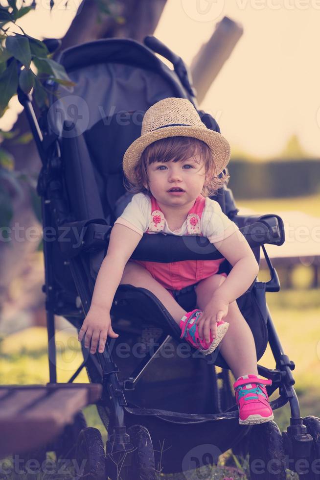 menina sentada no carrinho de bebê foto