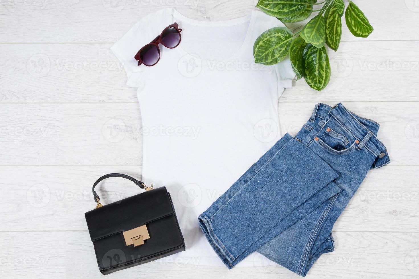 chinelos de camiseta feminina branca simulam postura plana em fundo de madeira. vista superior e copie o espaço. t-shirt de maquete e verão. modelo de camisa em branco. foto
