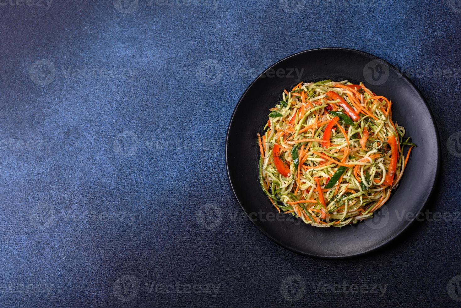 salada fresca de fatias finas de cenoura e abobrinha em um fundo de concreto foto