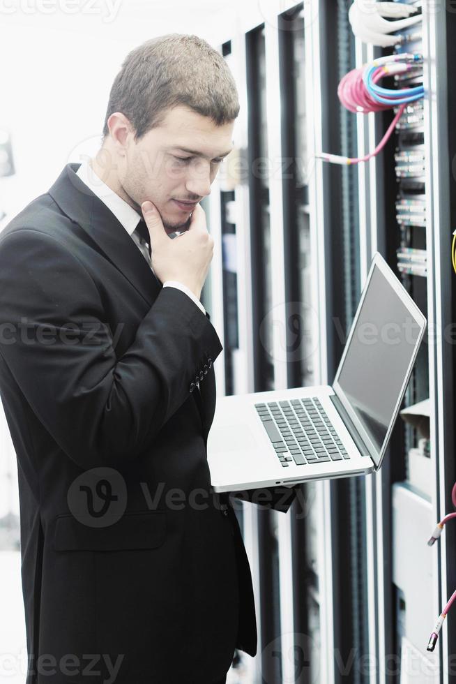 empresário com laptop na sala do servidor de rede foto