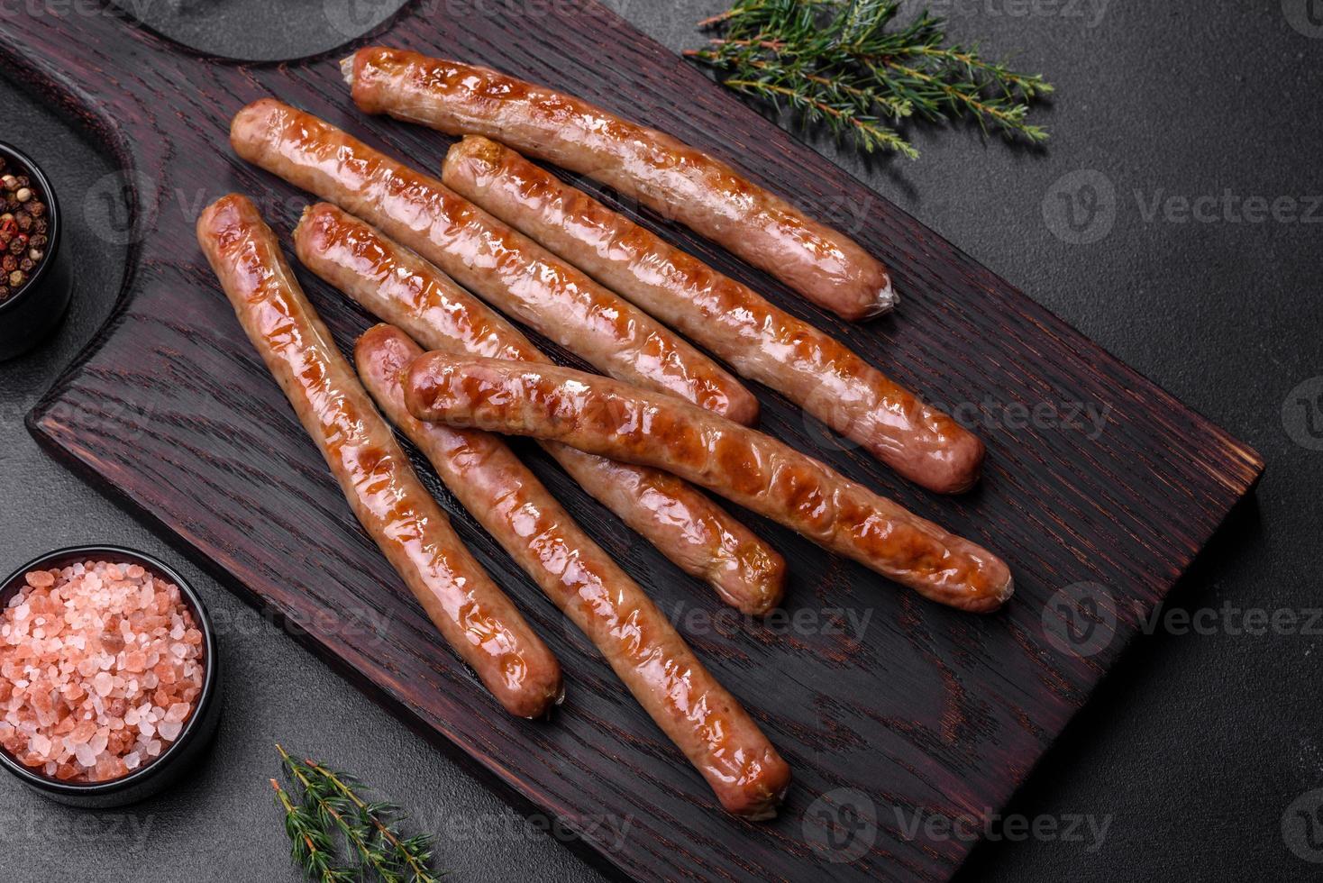 salsicha grelhada com adição de ervas e legumes na tábua de madeira foto