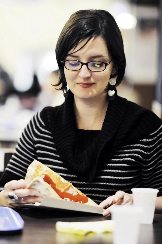 mulher come comida de pizza no restaurante foto
