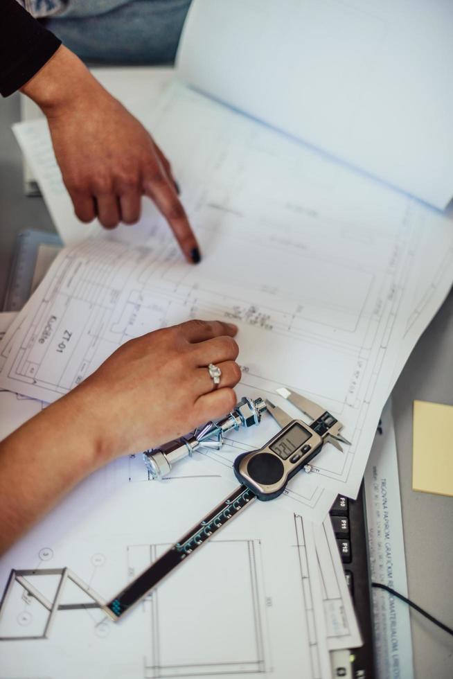 engenheiro técnico projetando desenhos peças mecânicas engenharia motorfabricação fábrica indústria trabalho industrial plantas de projeto rolamentos de medição calibrador ferramentas foto