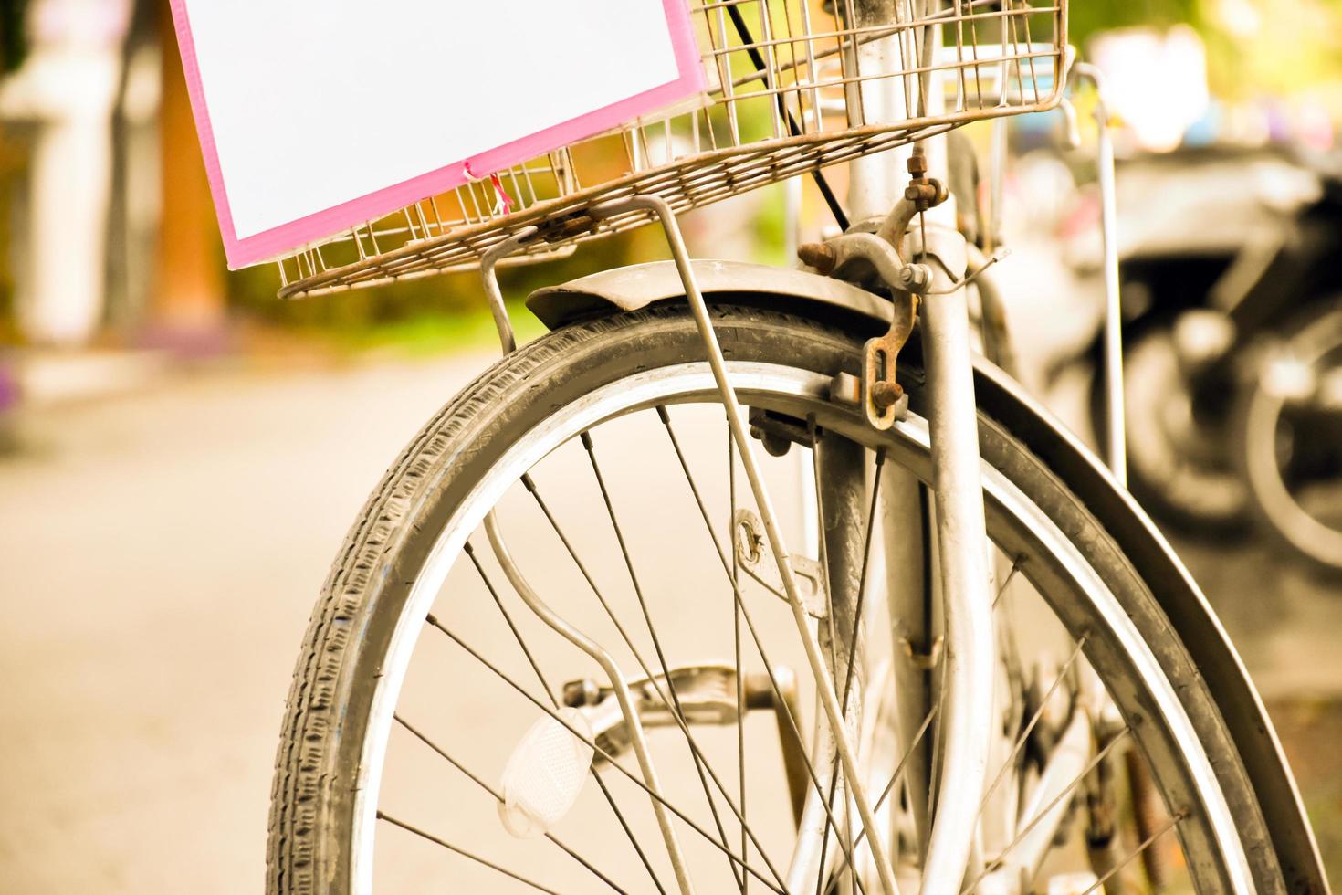 closeup vista do pneu traseiro furado da bicicleta vintage que estacionou na calçada ao lado da estrada. foco suave e seletivo. foto