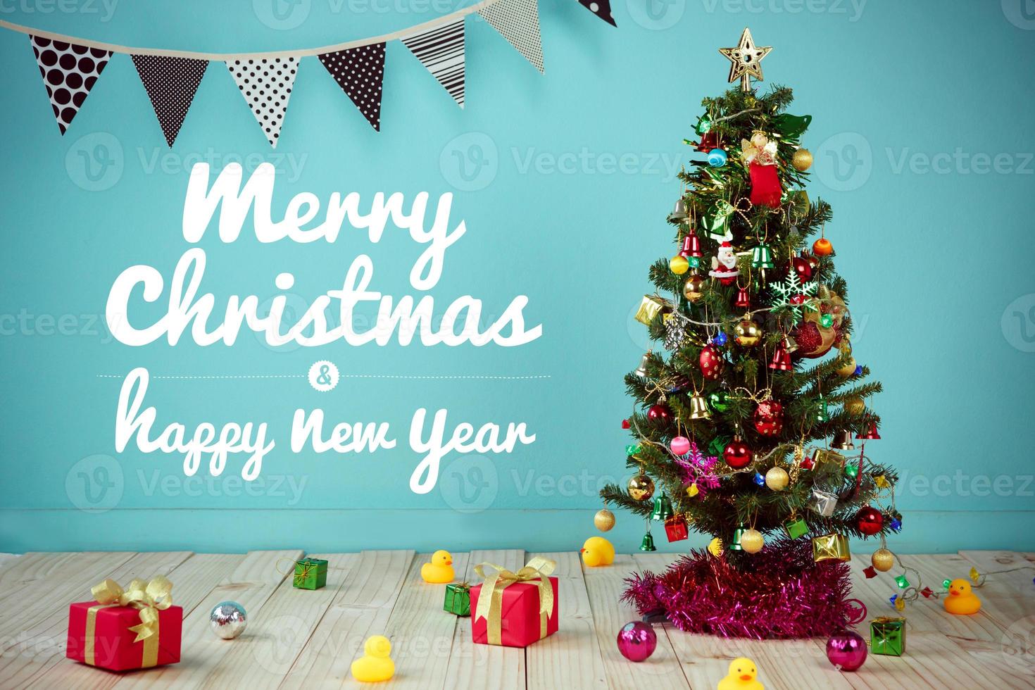 natal com item decorado pendurado em uma árvore e texto - feliz natal e feliz ano novo foto