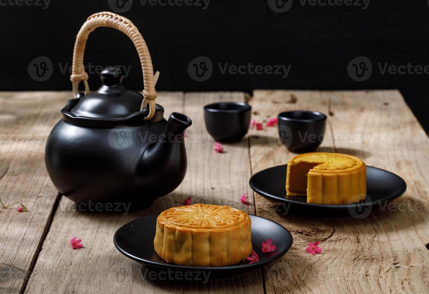 bolo de lua de comida deliciosa com uma xícara de chá quente no fundo da mesa de madeira com copyspace para o seu texto, conceito de festival tradicional chinês foto