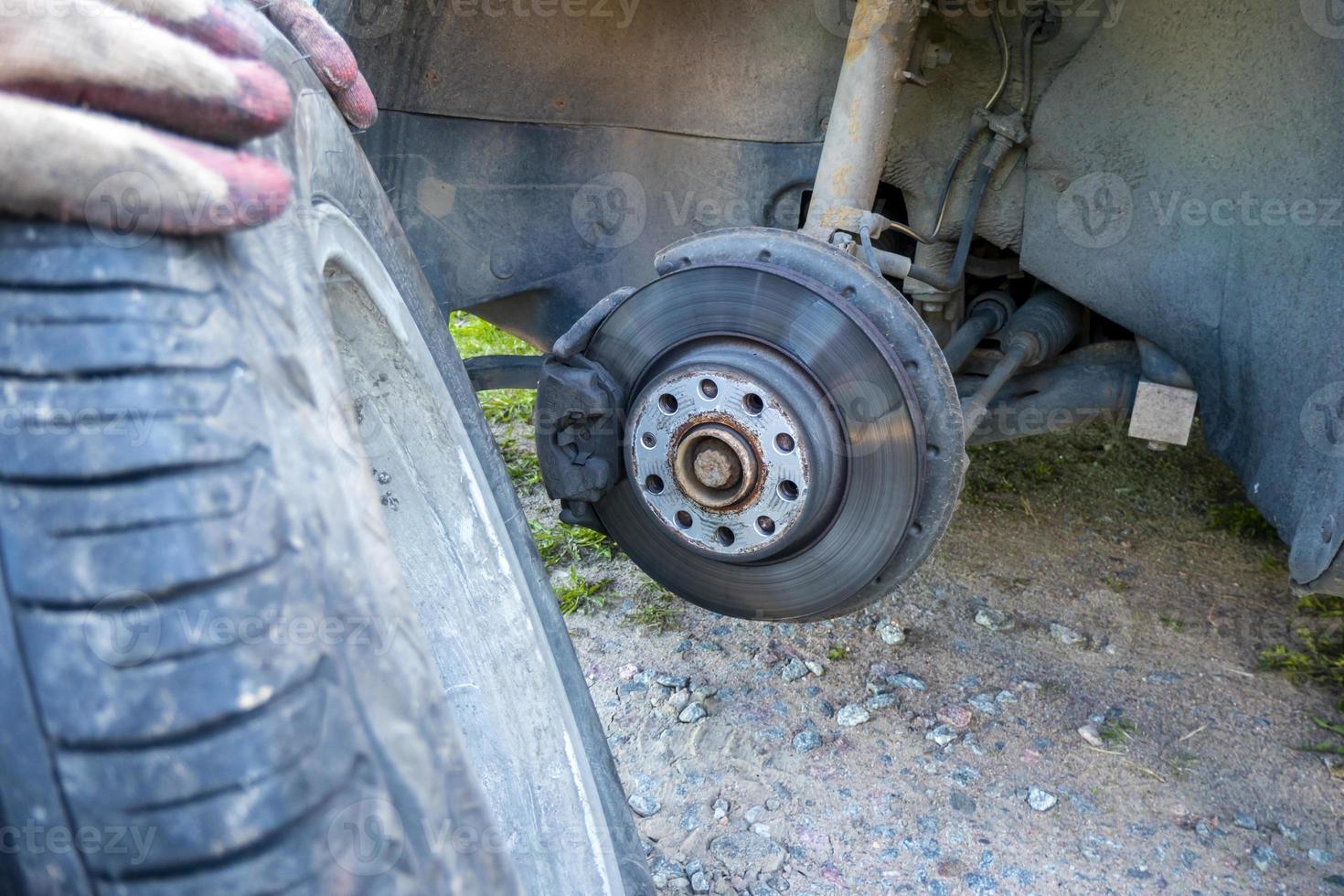 troque um pneu de carro furado na estrada com manutenção de pneus, pneu de carro danificado foto