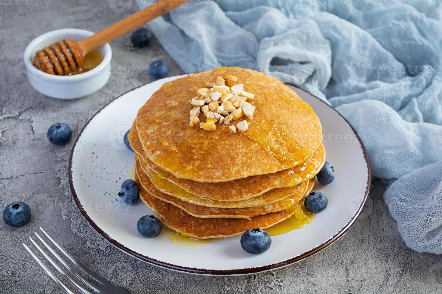 deliciosas panquecas caseiras com mel e mirtilos. saboroso café da manhã com crepes foto