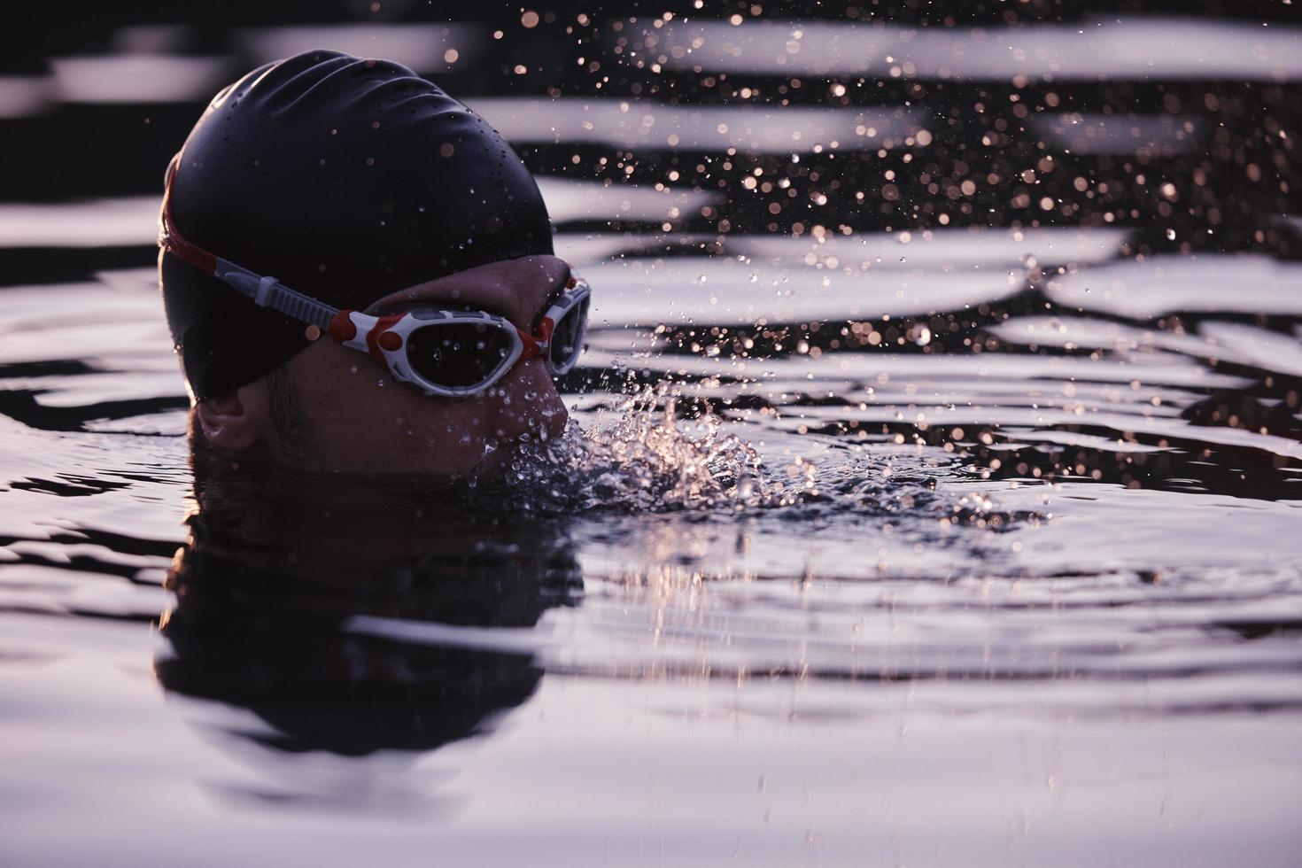 nadador triatleta tendo uma pausa durante o treinamento duro foto