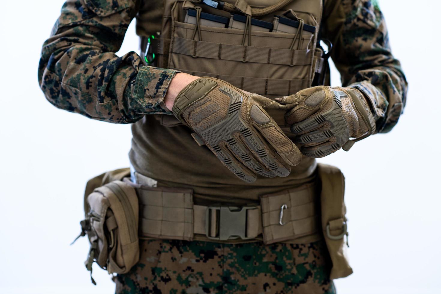 closeup de mãos de soldado colocando luvas de batalha protetoras foto