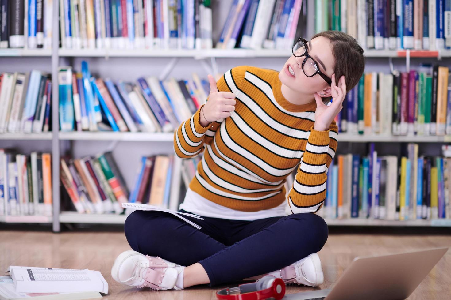 o aluno usa um notebook e uma biblioteca escolar foto