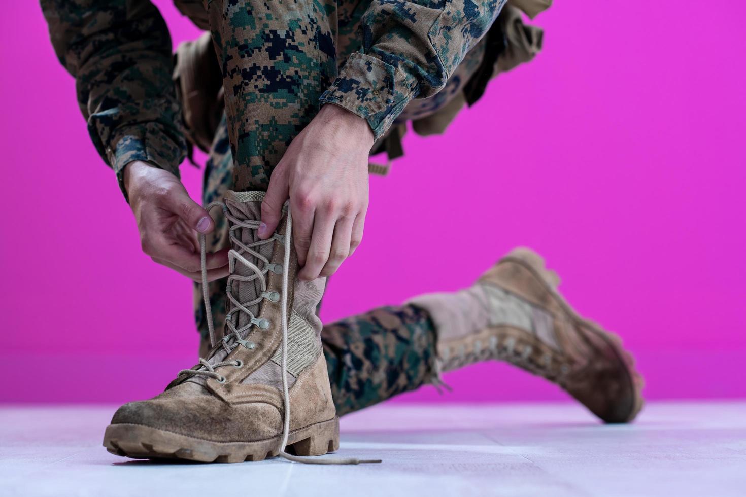 soldado amarrando os cadarços em suas botas foto