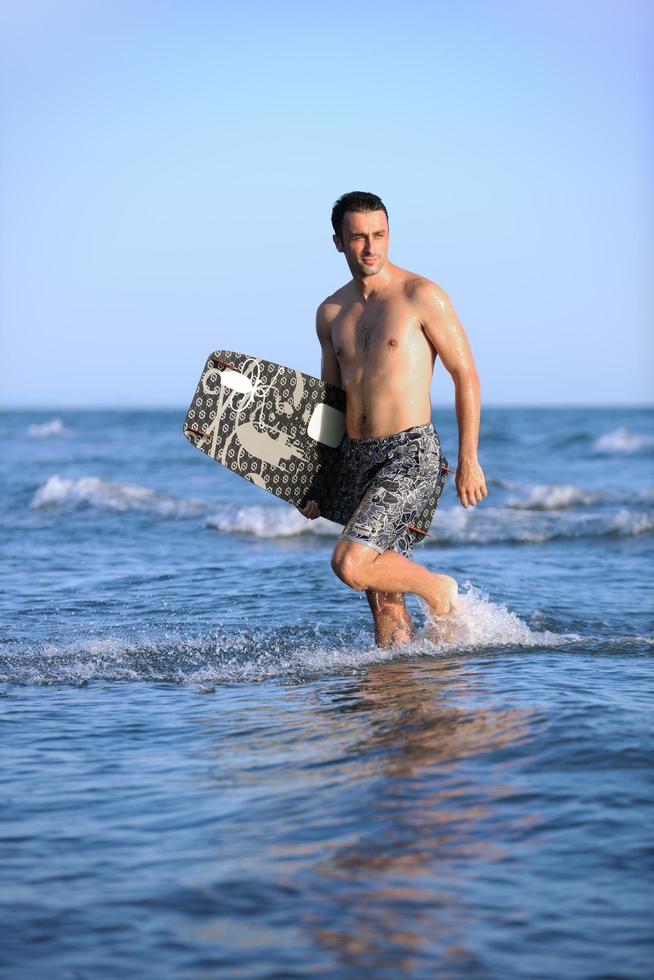 retrato de um jovem kitsurf na praia ao pôr do sol foto