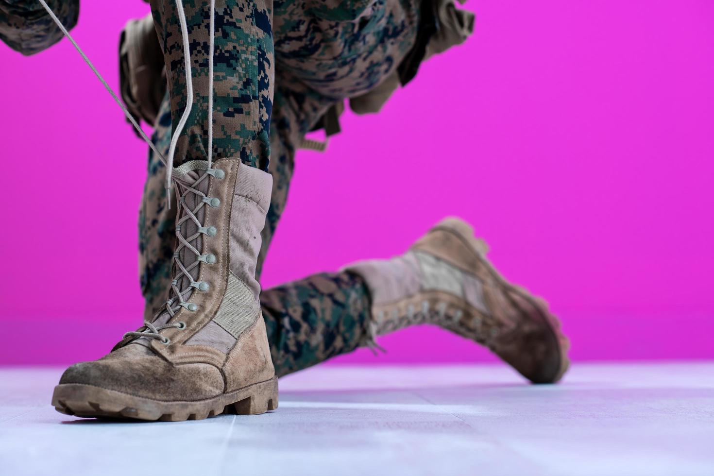 soldado amarrando os cadarços em suas botas foto