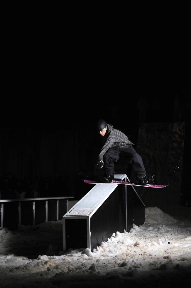 snowboarder freestyle pular no ar à noite foto