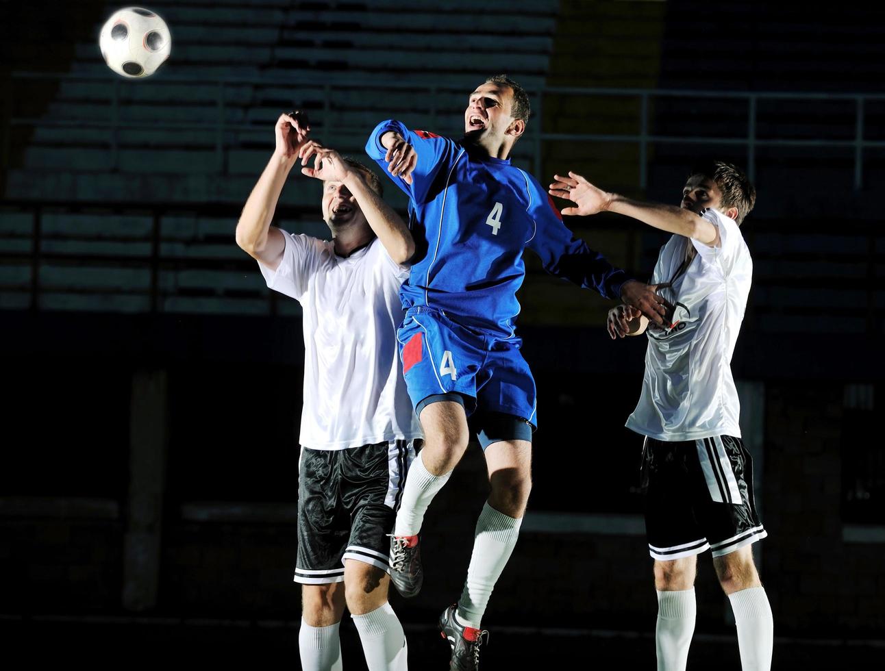 jogadores de futebol em ação para a bola foto