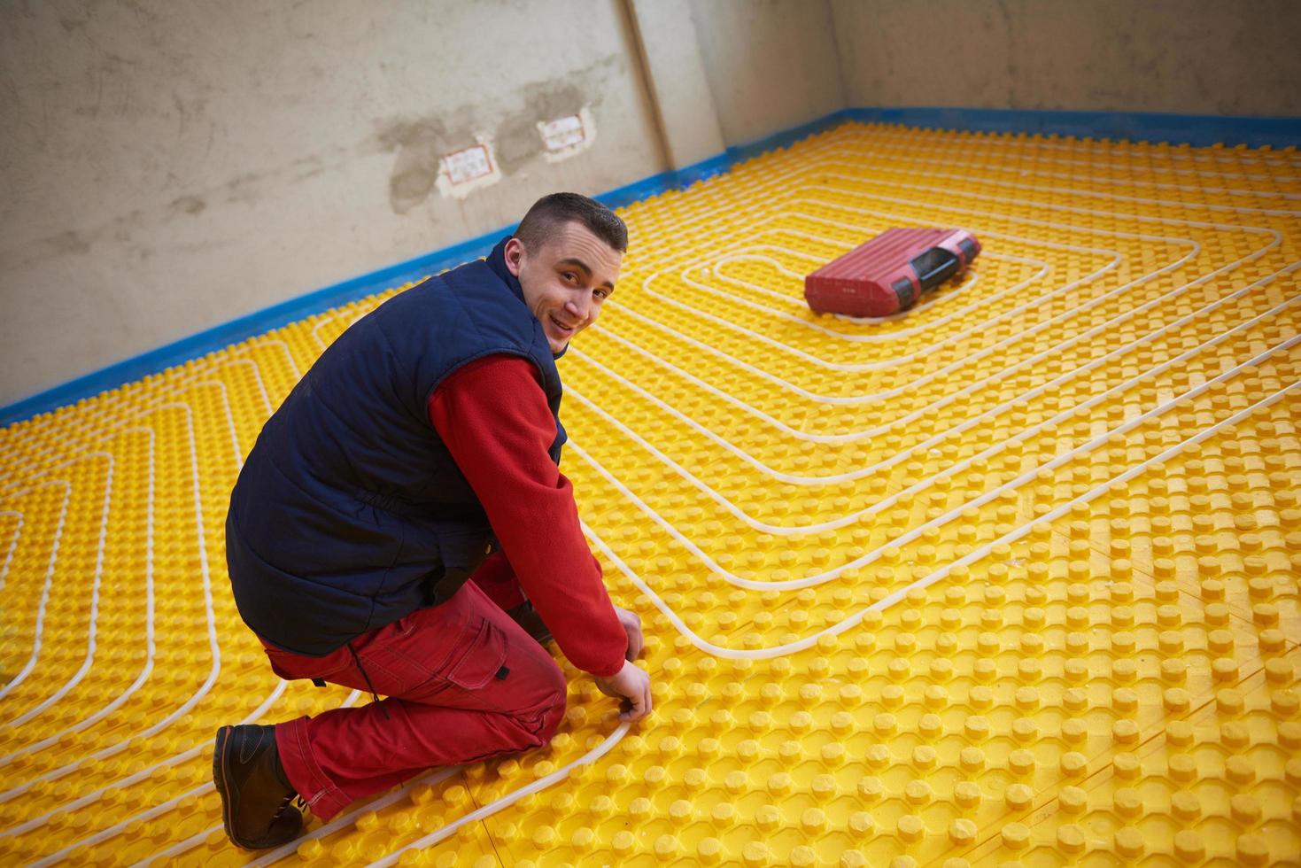 trabalhadores instalando sistema de piso radiante foto