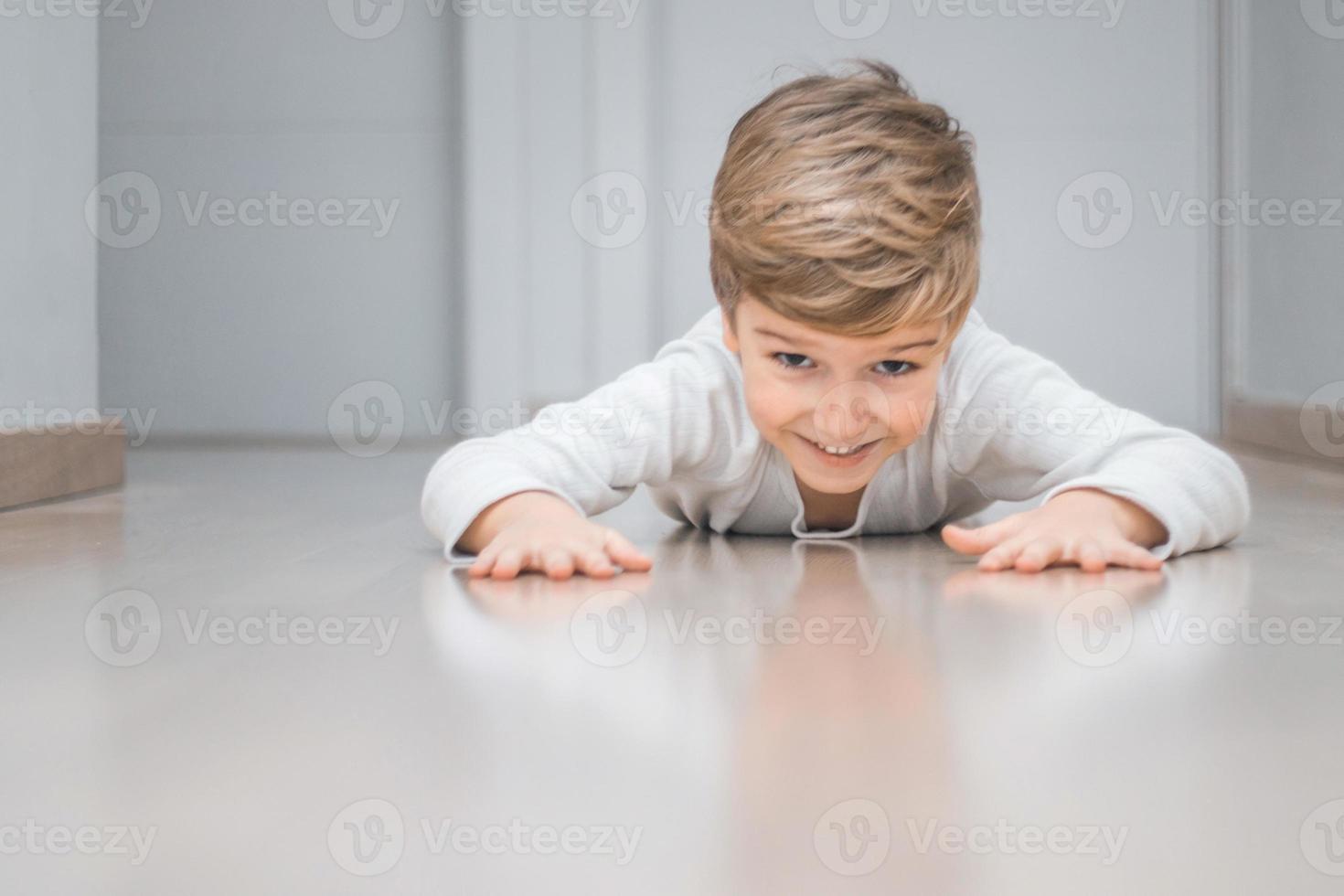 menino brincalhão rastejando no chão. foto