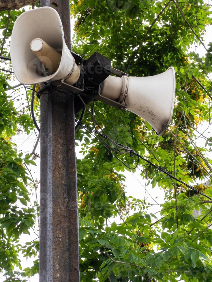 o velho megafone está pendurado no poste de dormente. foto