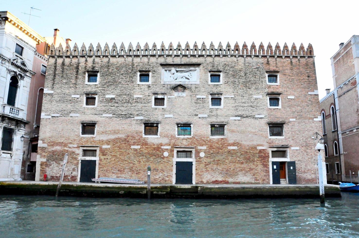 vista clássica do canal de veneza com edifícios típicos, janelas coloridas, pontes e barcos foto