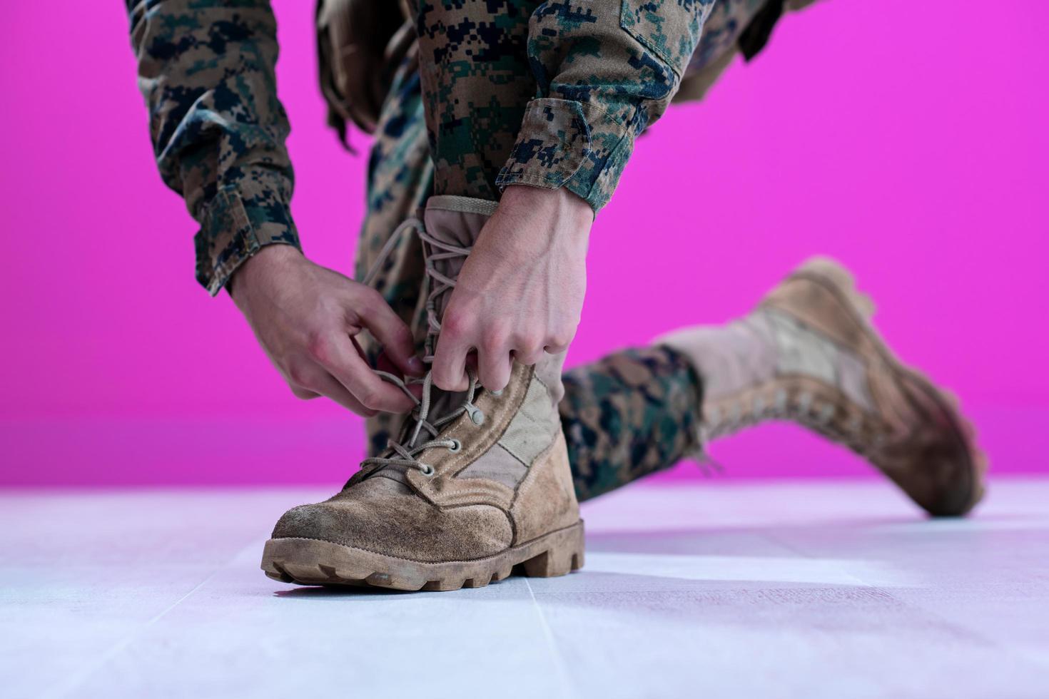 soldado amarrando os cadarços em suas botas foto