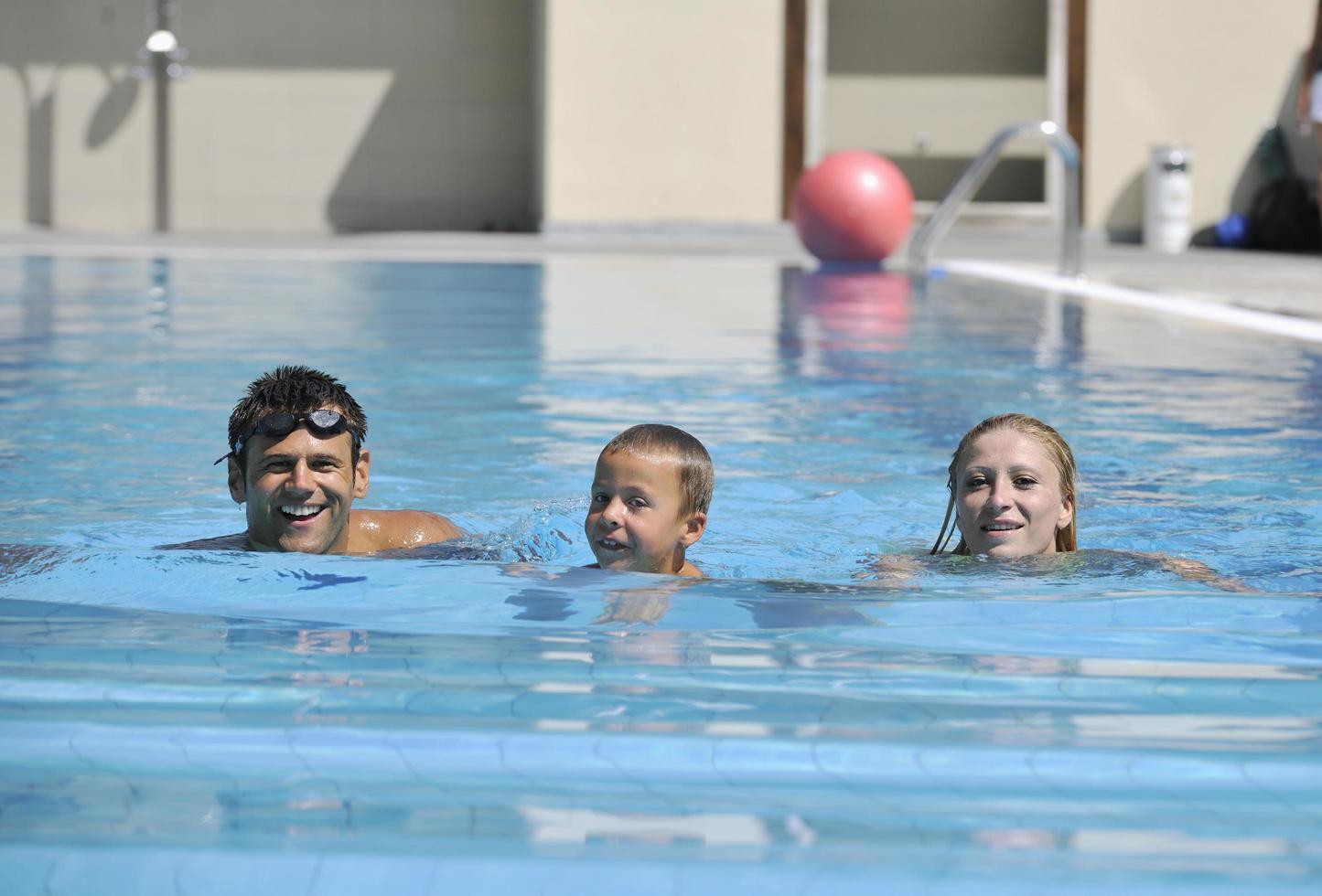 feliz jovem família se divertir na piscina foto